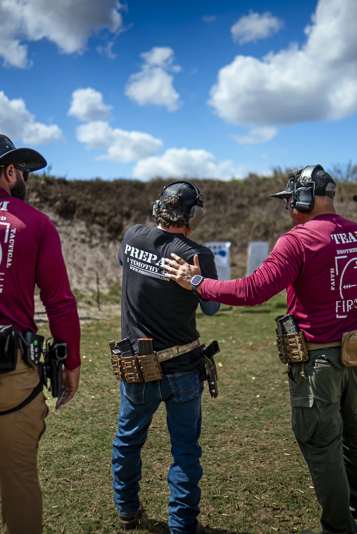 Coach with hand on trainee's back at the shooting range