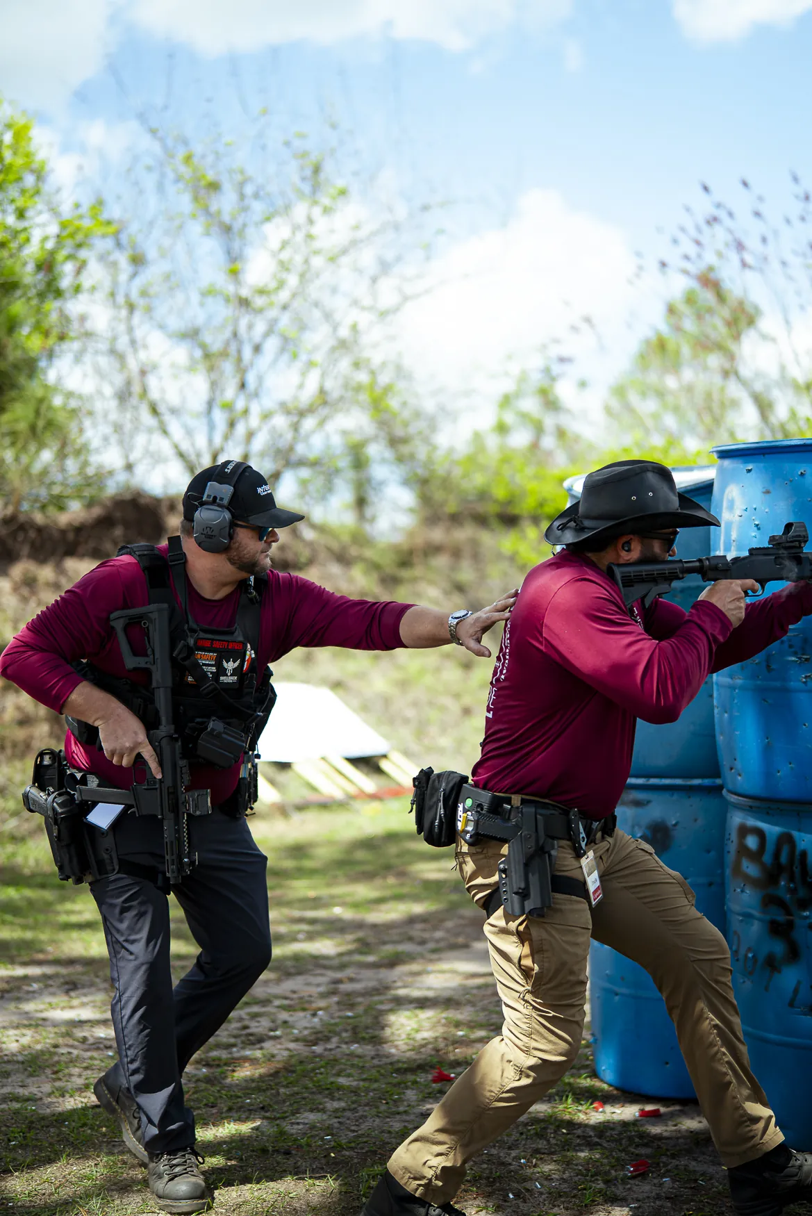Two men move between barricades with pistols drawn