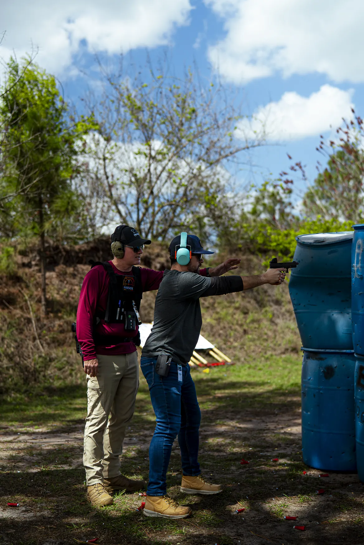 A Fireside coach adjusts a man&rsquo;s stance on the pistol line